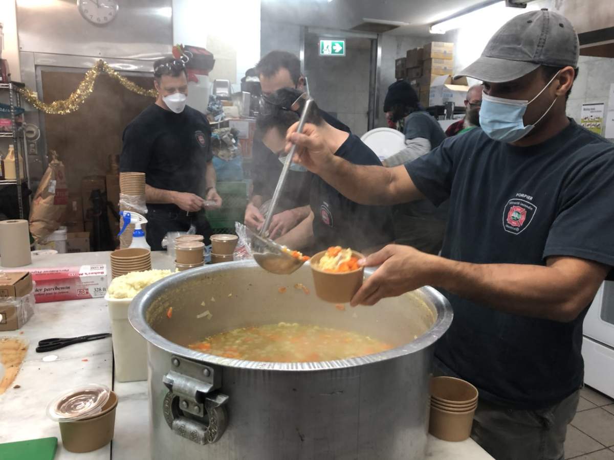 Firefighter preparing a warm meal at Resilience Montreal day shelter on Thursday, Dec. 17, 2020.