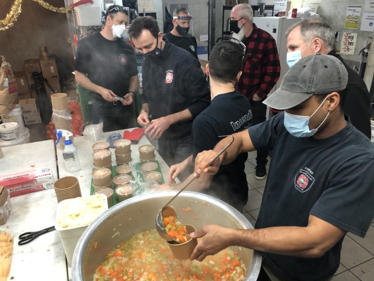 Firefighters serving food at a Resilience Montreal homeless day shelter in Montreal on Thursday Dec.17, 2020.