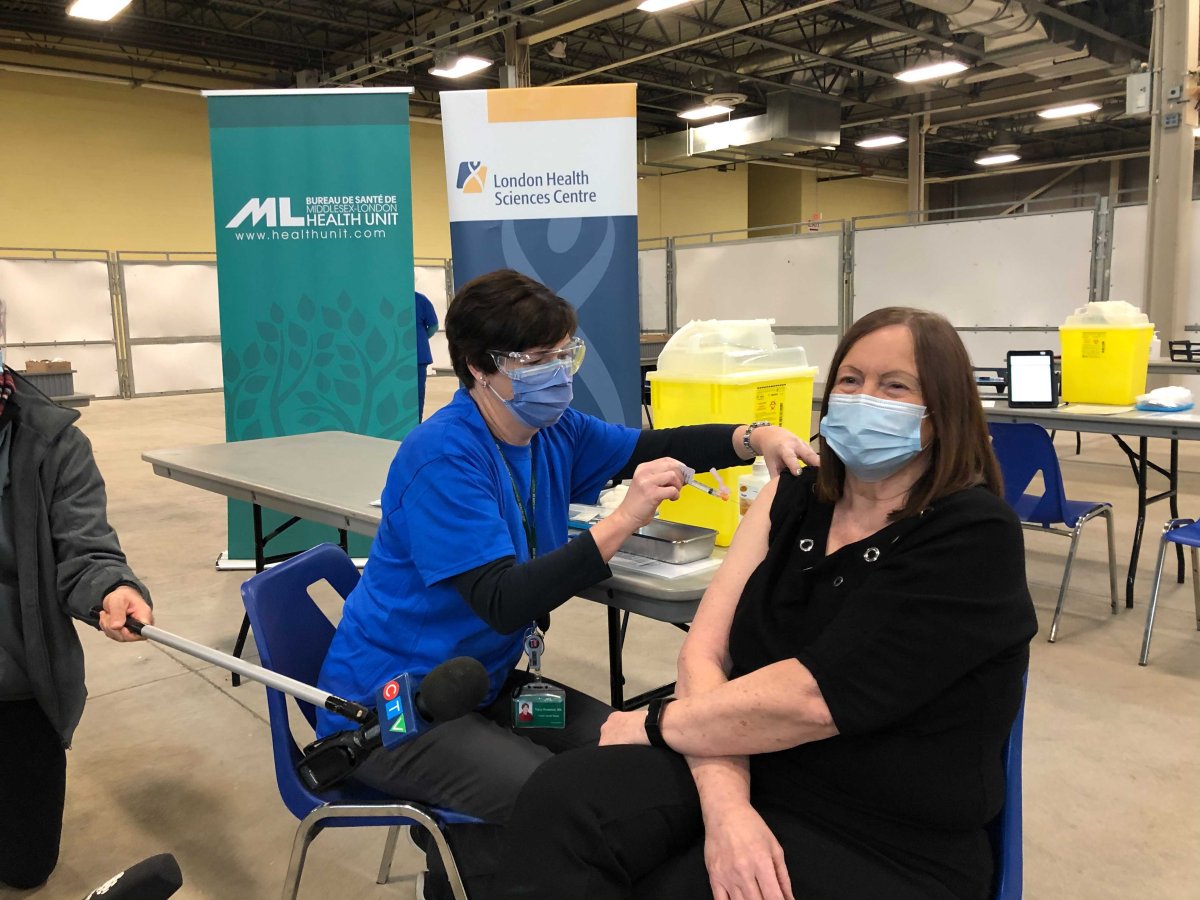 Karen Dann receives the first COVID-19 vaccine administered by the Middlesex-London Health Unit during an appointment at the Western Fair Agriplex on Wednesday, Dec. 23, 2020.