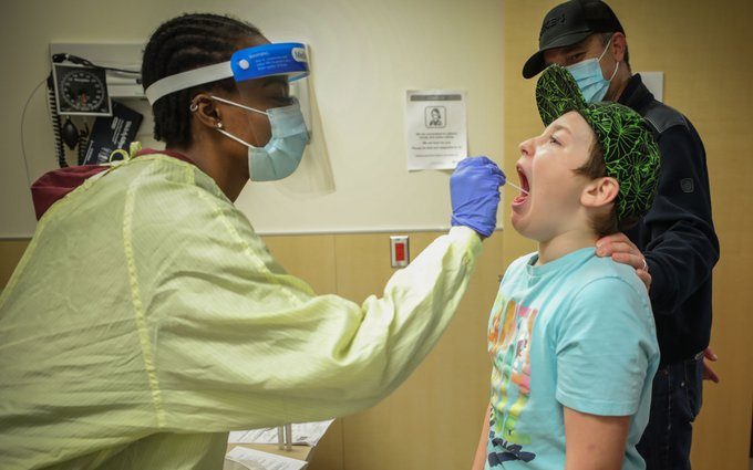 An Alberta Health Services worker swabs a child to test for COVID-19, Jan. 2021.