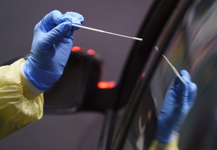 A nurse uses a swab to perform a test on a patient at a drive-in COVID-19 clinic in Montreal, on Wednesday, October 21, 2020.