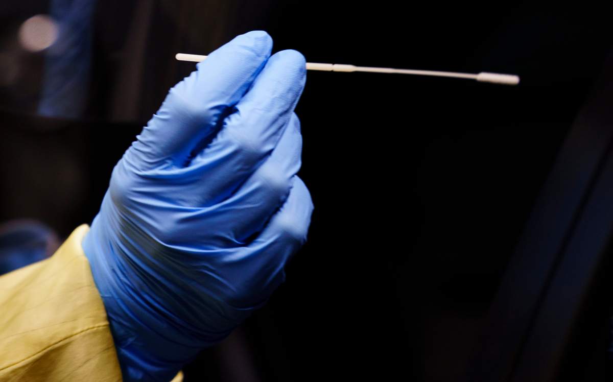 A nurse uses a swab to perform a test on a patient at a drive-in COVID-19 clinic in Montreal, on Wednesday, October 21, 2020. THE CANADIAN PRESS/Paul Chiasson.
