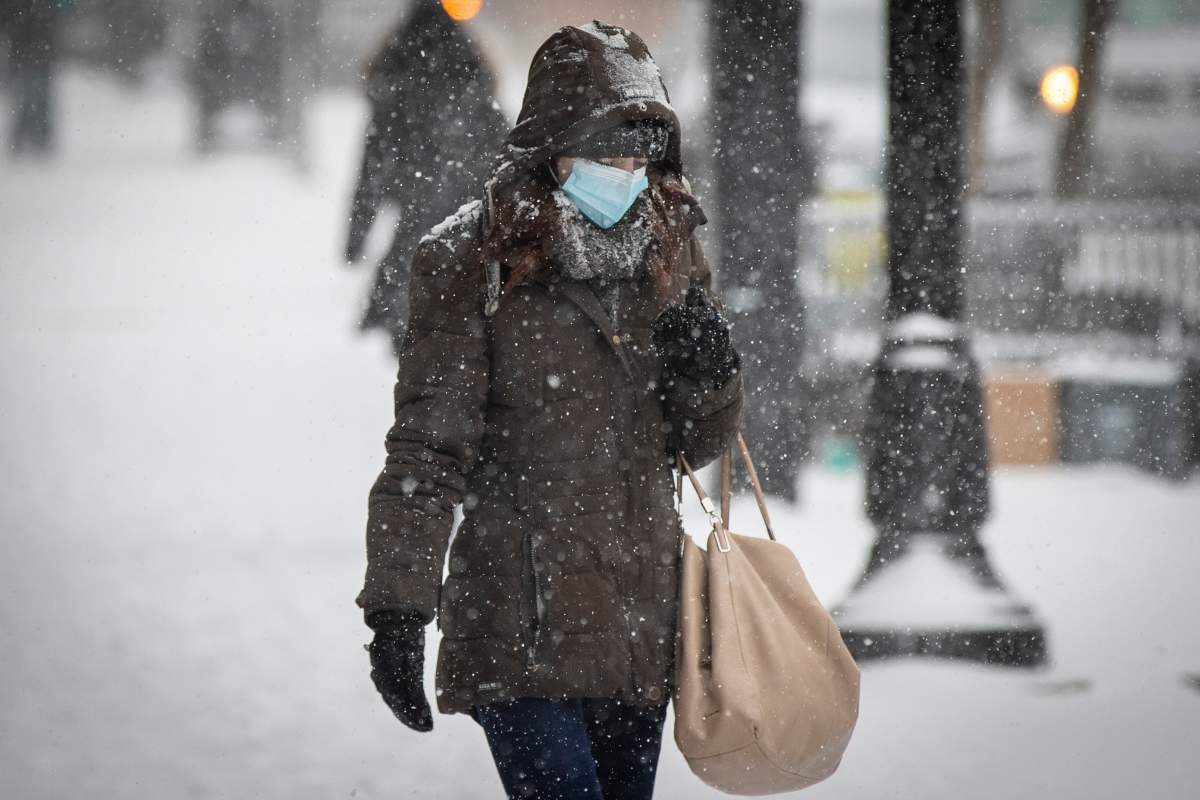 A person wears a disposable mask to protect them from the COVID-19 virus during a snow squall in Kingston, Ontario on Tuesday, January 26, 2021. 