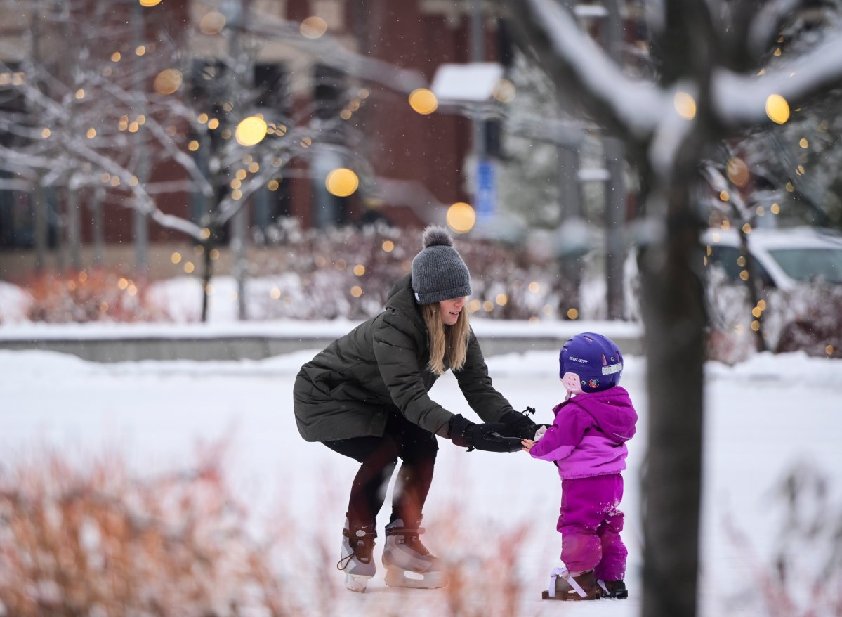 A mom teachers her daughter to skate at Landsdowne Park in Ottawa on Wednesday, Dec. 9, 2020. 