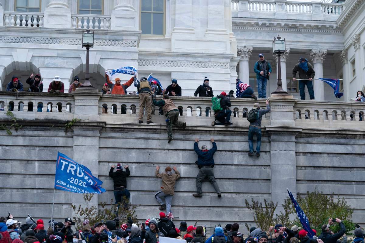 Supporters of U.S. President Donald Trump climb the west wall of the U.S. Capitol on Wednesday.