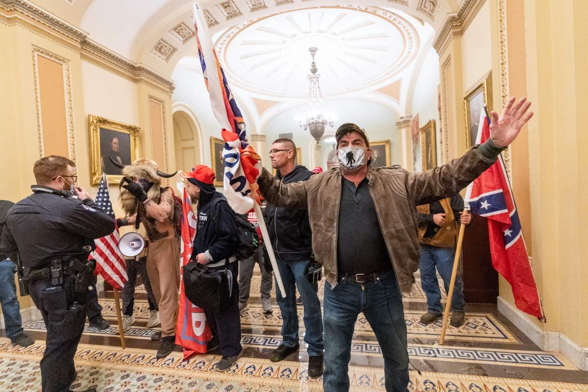 Supporters of U.S. President Donald Trump are confronted by U.S. Capitol Police officers outside the Senate Chamber inside the Capitol, Wednesday, Jan. 6, 2021 in Washington.