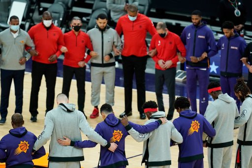 Members of the Phoenix Suns and the Toronto Raptors form a circle during the American national anthem prior to an NBA basketball game Wednesday, Jan. 6, 2021, in Phoenix.