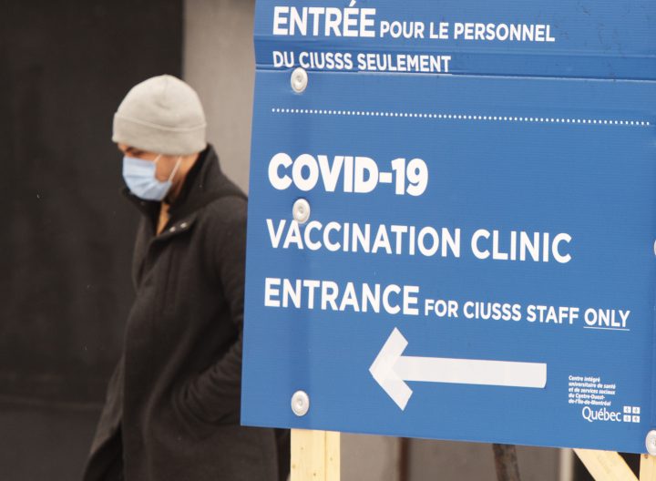 A man walks past the COVID-19 vaccination site at Maimonides long-term care facility Wednesday, Jan. 13, 2021 in Montreal.