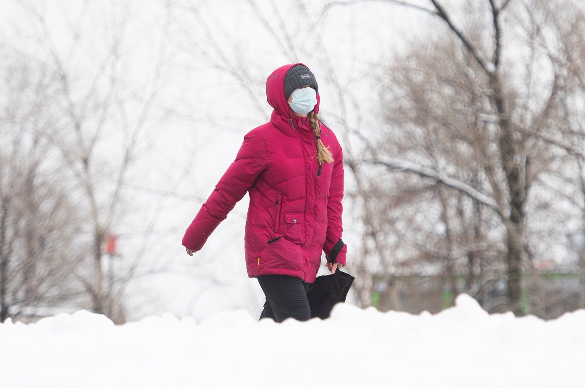 A woman wears a face mask as she walks along the Lachine Canal in Montreal, Sunday, January 17, 2021, as the COVID-19 pandemic continues in Canada and around the world. 
