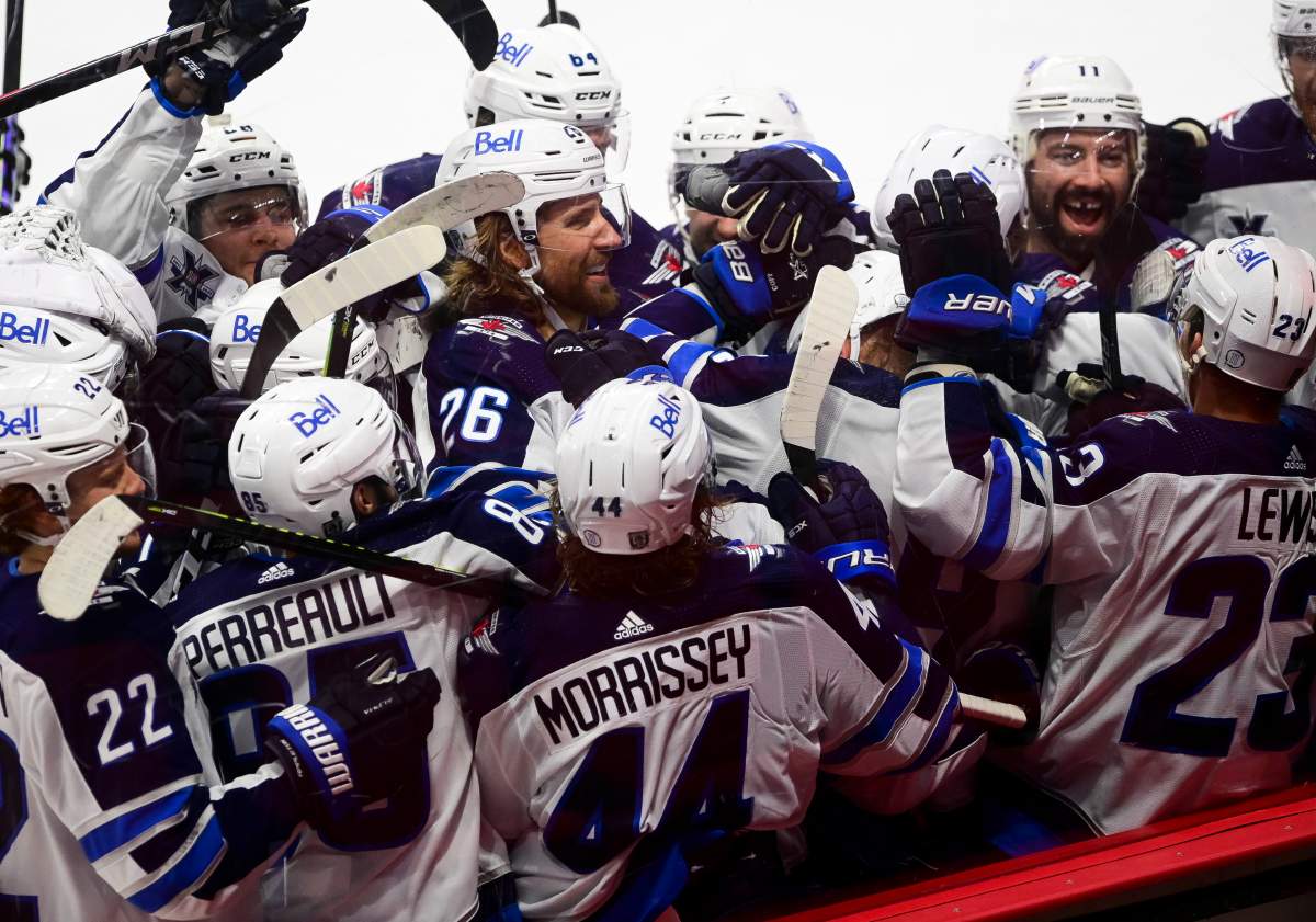 Winnipeg Jets players gather around Nikolaj Ehlers (27) after he scored the game winning goal past Ottawa Senators goaltender Matt Murray in overtime NHL action in Ottawa on Tuesday, Jan. 19, 2021. 