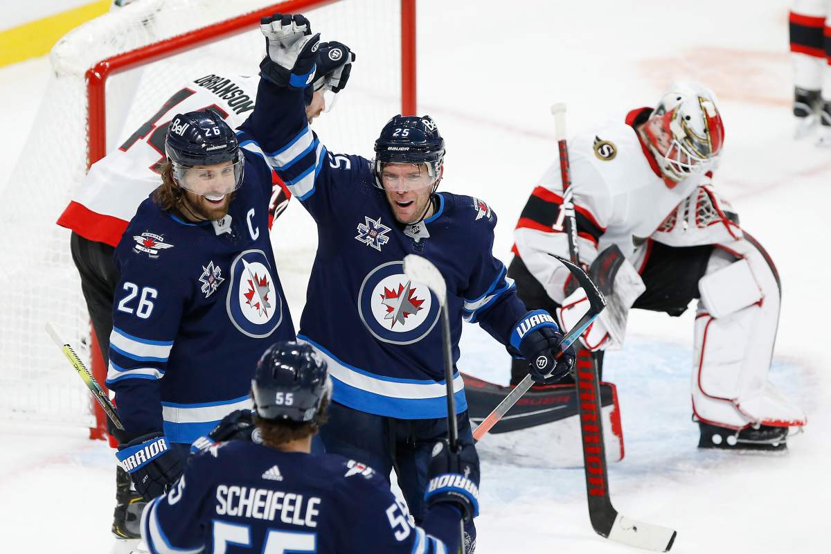 Winnipeg Jets' Mark Scheifele (55), Blake Wheeler (26) and Paul Stastny (25) celebrate Stastny's game winning goal against Ottawa Senators goaltender Marcus Hogberg (1) during third period NHL action in Winnipeg on Saturday, January 23, 2021.