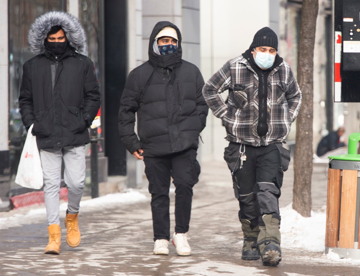 People brave the cold and COVID-19 as they make their way along Ste-Catherine Street, Monday, Jan. 25, 2021 in Montreal.