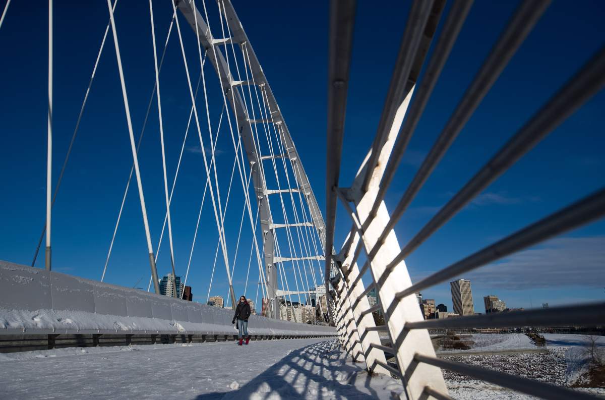 A woman walks across the Walterdale Bridge, in Edmonton, Alta., on Friday, Dec. 27, 2019.