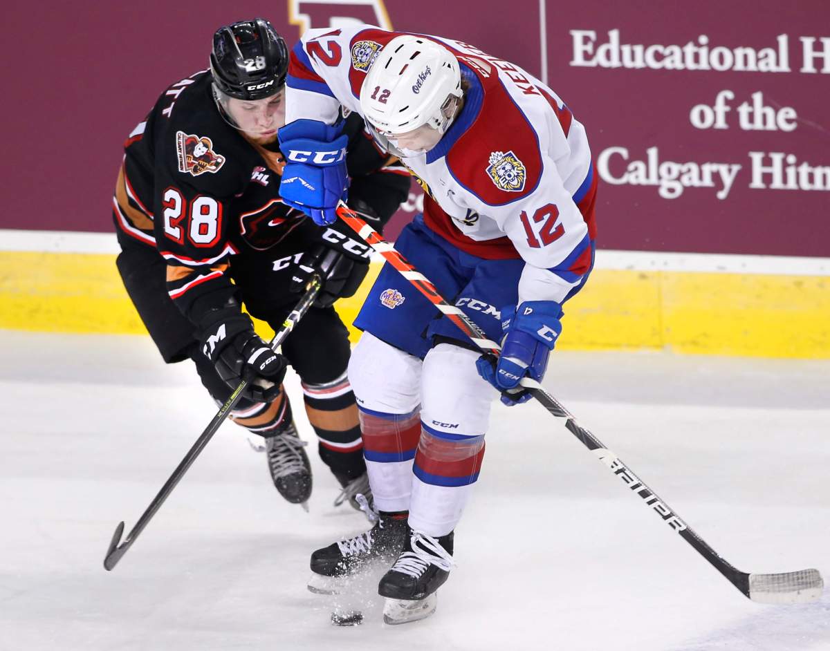 Edmonton Oil Kings player Liam Keeler, rt, battles for the puck with Calgary Hitmen player Orca Wiesblatt during WHL (Western Hockey League) hockey action in Calgary, Alta., on Friday, Dec. 6, 2019. 