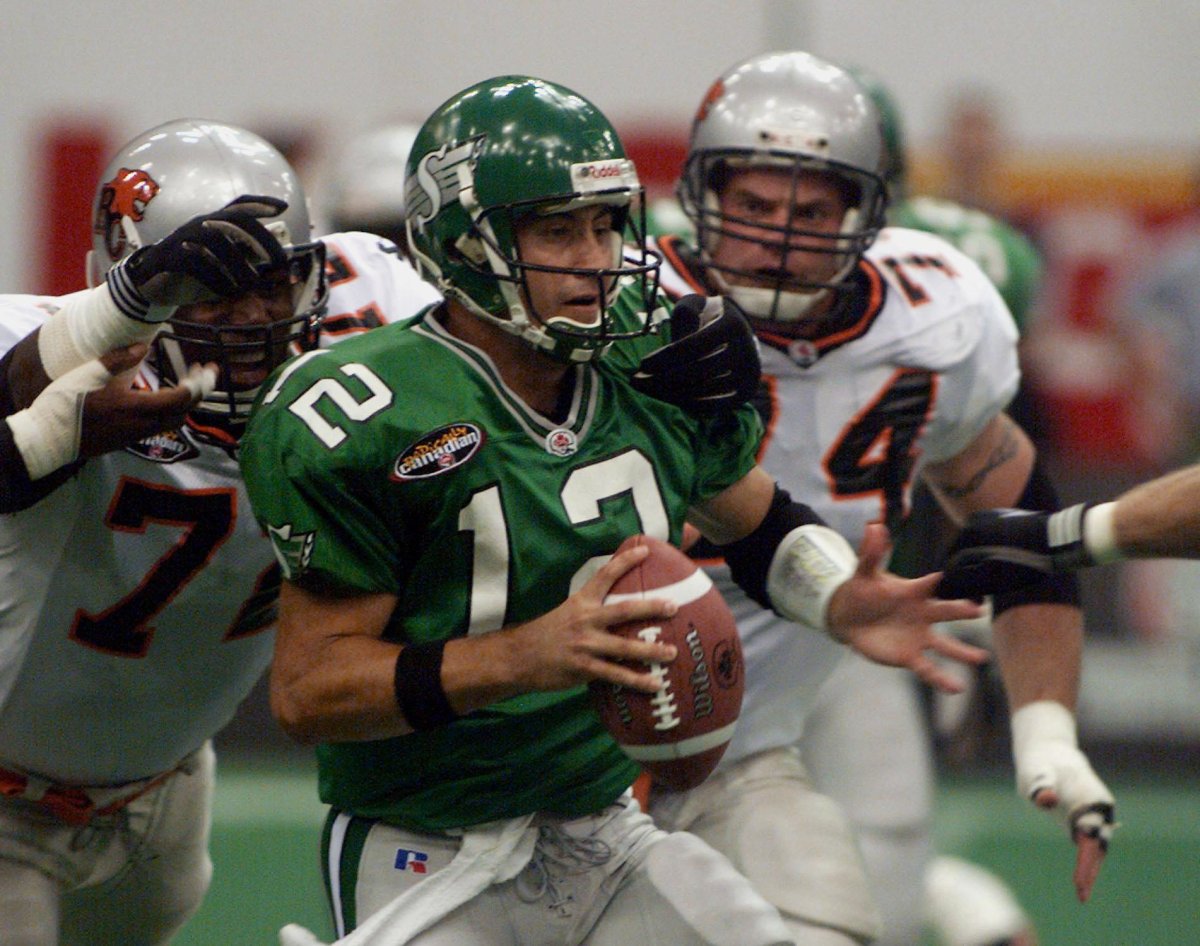 Saskatchewan Roughriders quarterback Steve Sarkisian is chased down by B.C. Lions Johnny Scott and Dave Chaytors during first half of CFL action in Vancouver on Aug. 26, 1999.