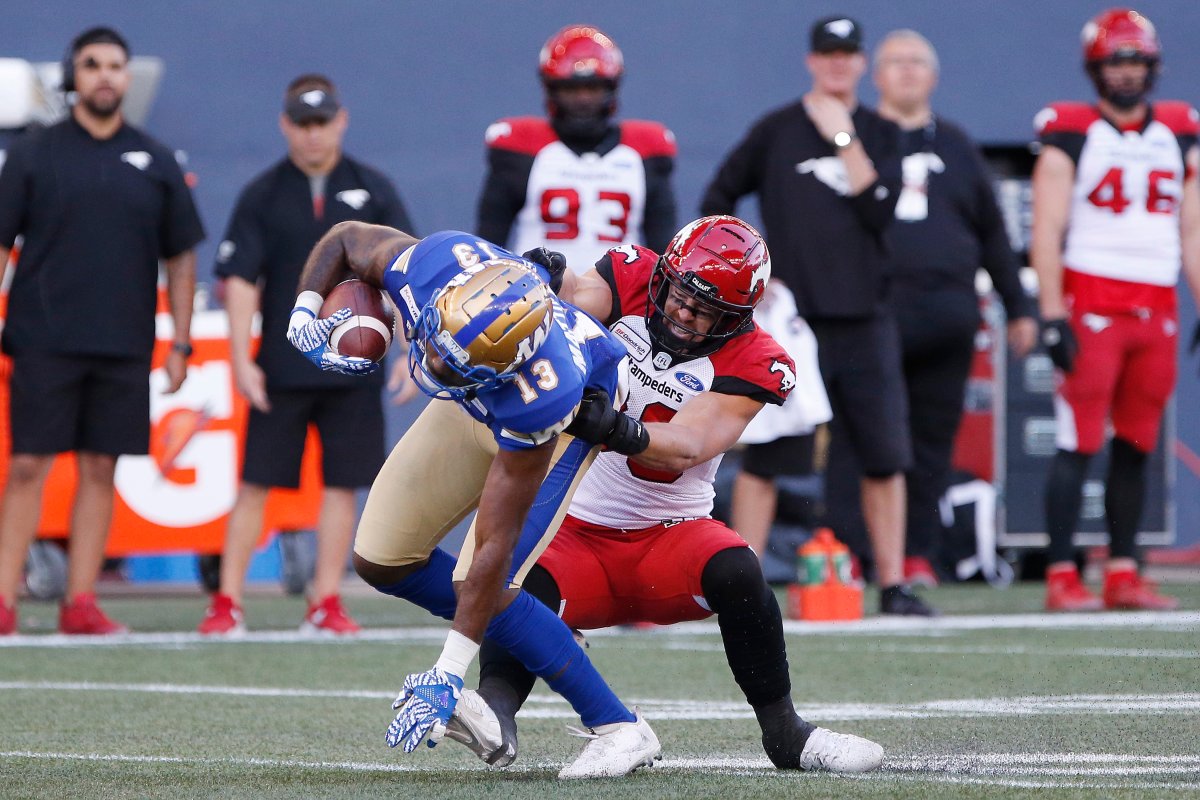 Winnipeg Blue Bombers' Chris Matthews (13) gets tackled by Calgary Stampeders' Cory Greenwood (36) during the first half of CFL action in Winnipeg Thursday, August 8, 2019. 