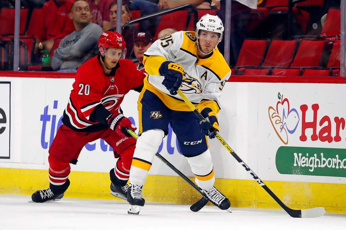 Nashville Predators' Matt Duchene (95) moves the puck away from Carolina Hurricanes' Sebastian Aho (20) during the first period of an NHL preseason hockey game, in Raleigh, N.C, Friday, Sept. 27, 2019.