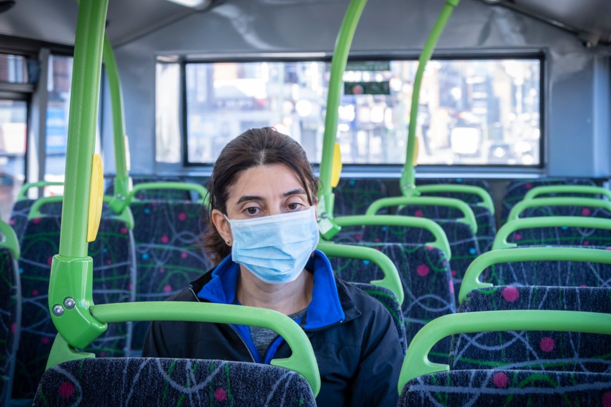 A commuter on her way to work using a face mask on a double-decker bus, during a health lockdown.
