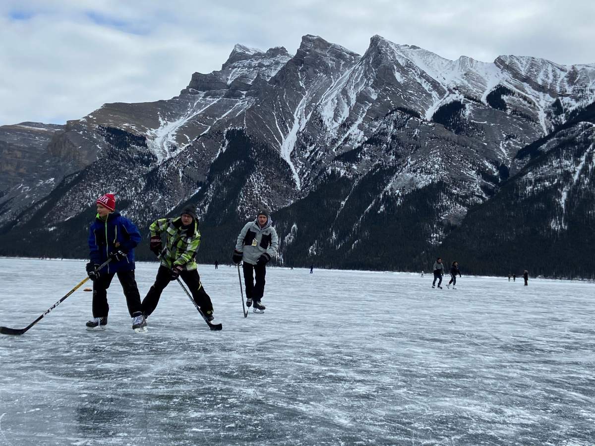 A group plays shinny hockey on Lake Minnewanka near Banff, Alta., Sunday, Jan. 24, 2021.