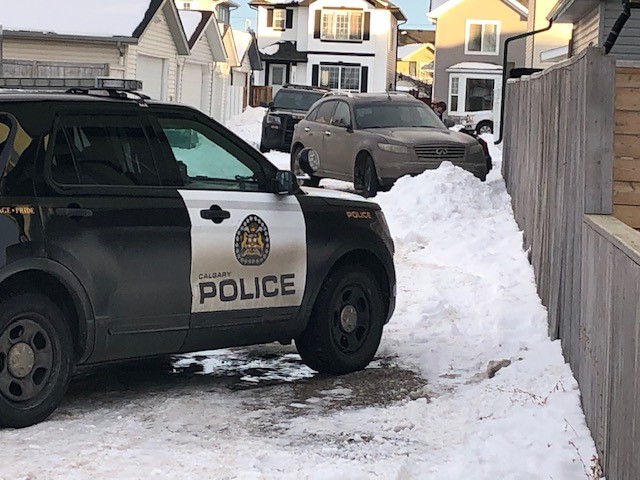 Calgary police cars surround the suspect vehicle involved in a hit and run that left a police officer dead on New Year’s Eve.