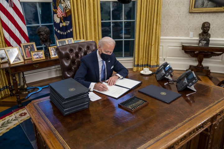 U.S. President Joe Biden signs executive orders during his first minutes in the Oval Office, in the White House, Washington, D.C., on Jan. 20, 2021.