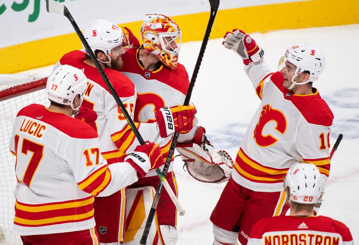 Calgary Flames goaltender Jacob Markstrom celebrates with teammates after defeating the Montreal Canadiens in an NHL hockey game in Montreal, Saturday, January 30, 2021.THE CANADIAN PRESS/Graham Hughes.