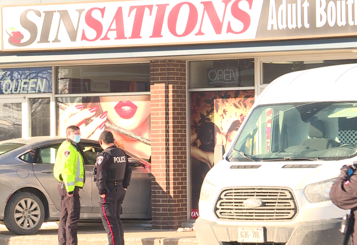 Kingston police say a woman was sent to hospital after a vehicle smashed into a sex shop Thursday afternoon.