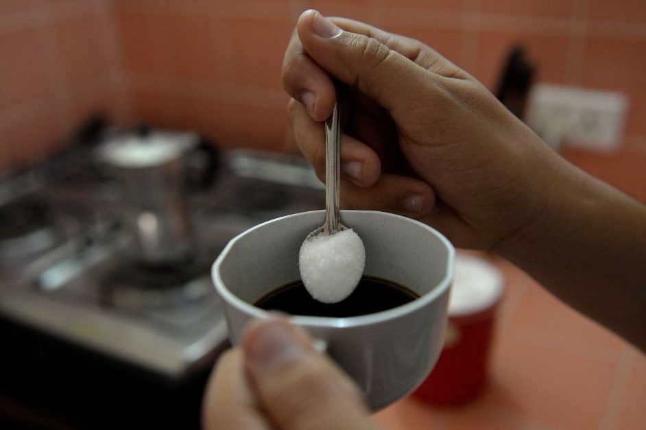 A woman puts sugar in her coffee in this file photo from Oct. 9, 2018.