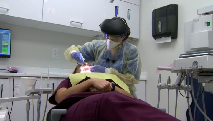 Dentist in Manitoba wearing additional personal protective equipment which treating patients in 2020.
