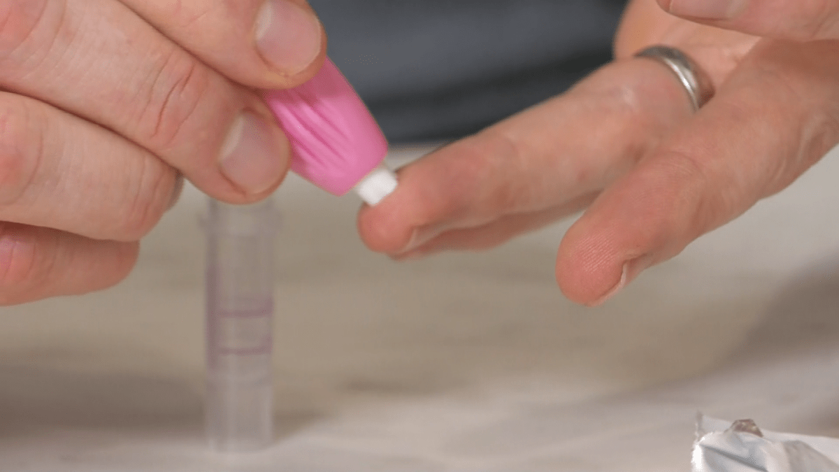 Hart Jackson pricks his finger to provide a blood sample to test for COVID-19 antibodies.
