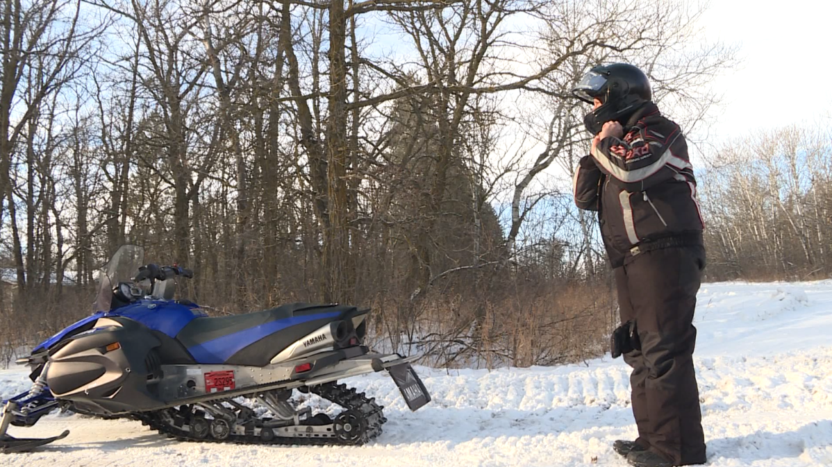 Greg Bruce strapping on his helmet before riding near Stonewall, Man.