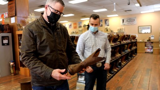 Minister of Finance Travis Toews purchases new boots at the Alberta Boot Company in Calgary for Budget 2021.