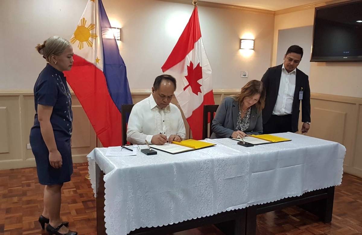 Supt. Marie-Claude Arsenault signing an agreement with the Philippines to cooperate stop child sex trafficking.
