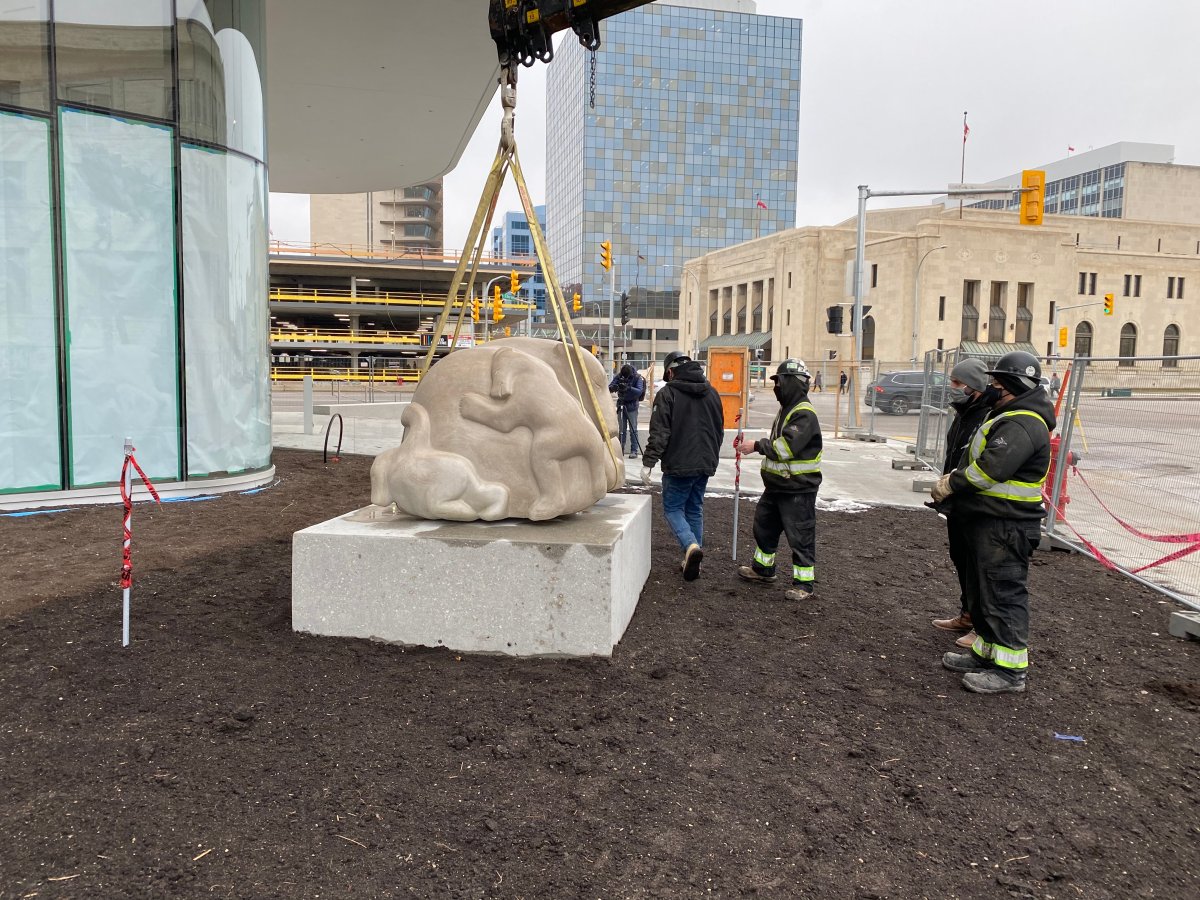 Workers install "Time to Play" by Abraham Anghik Ruben outside the WAG's new Inuit Art Centre.