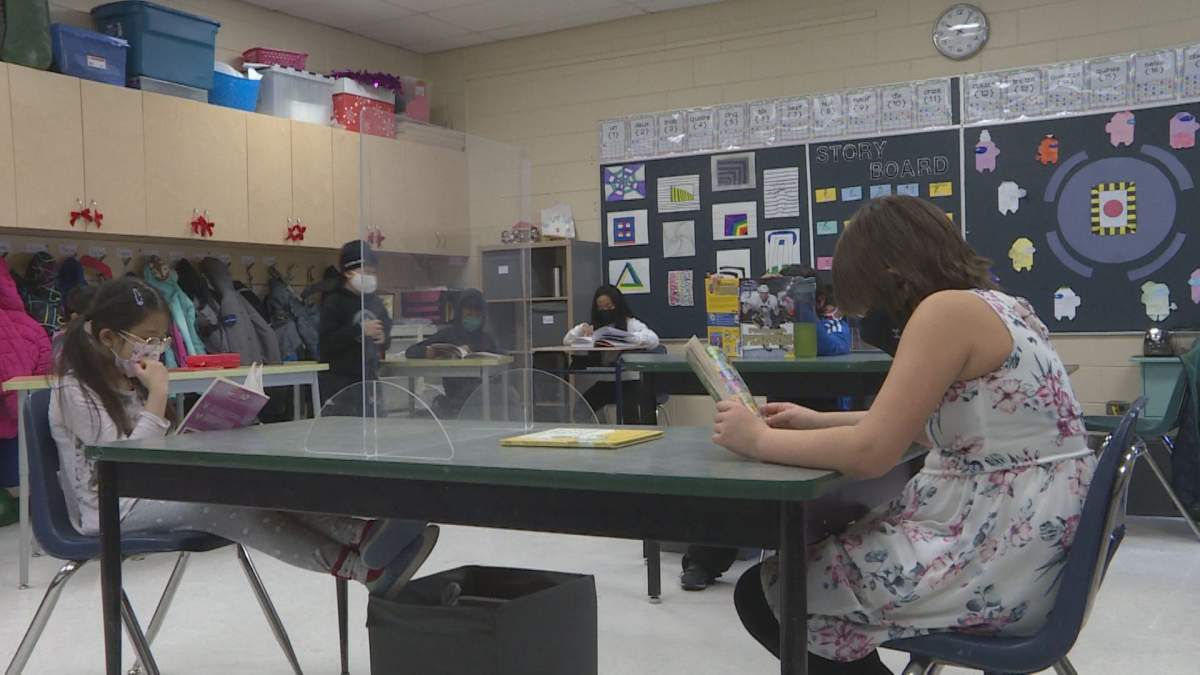 Plexiglass barriers separate students in a Grade 4 classroom.