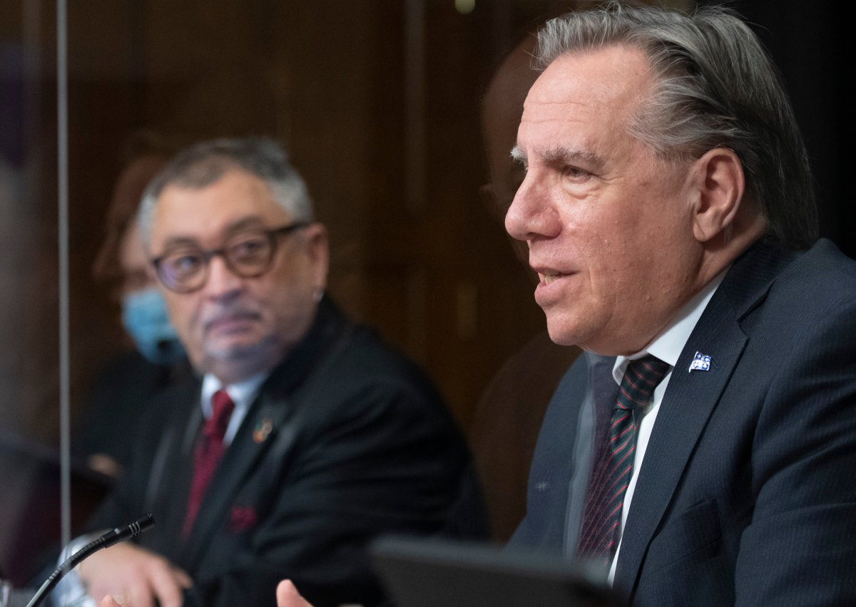 Quebec Premier Francois Legault speaks during a news conference on the COVID-19 pandemic, at the legislature in Quebec City, Wednesday, Dec. 9, 2020.  Horacio Arruda, Quebec director of National Public Health, left, looks on. 