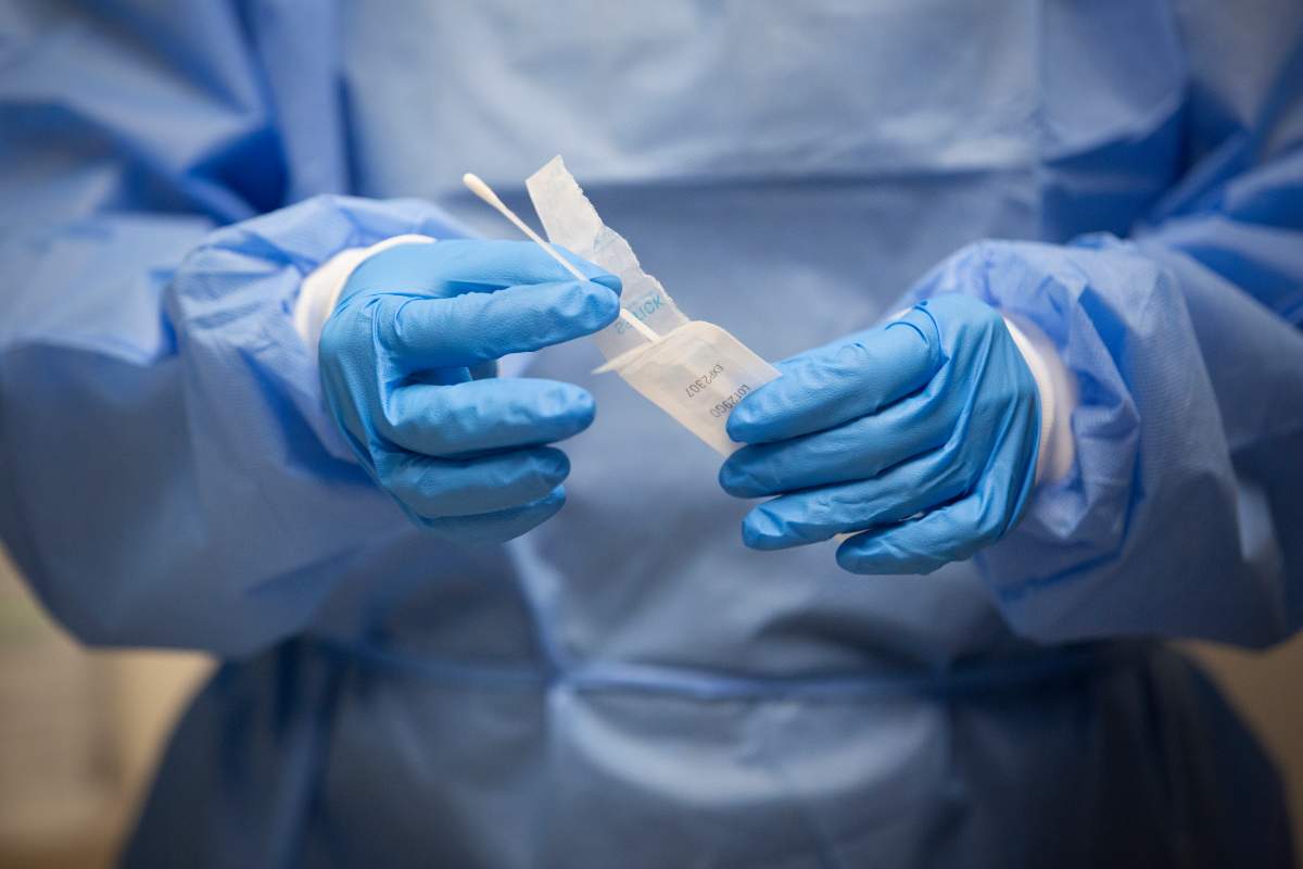 A pharmacist holds a COVID-19 test swab at a pharmacy in Amherstview, Ontario on Friday, January 22, 2021.