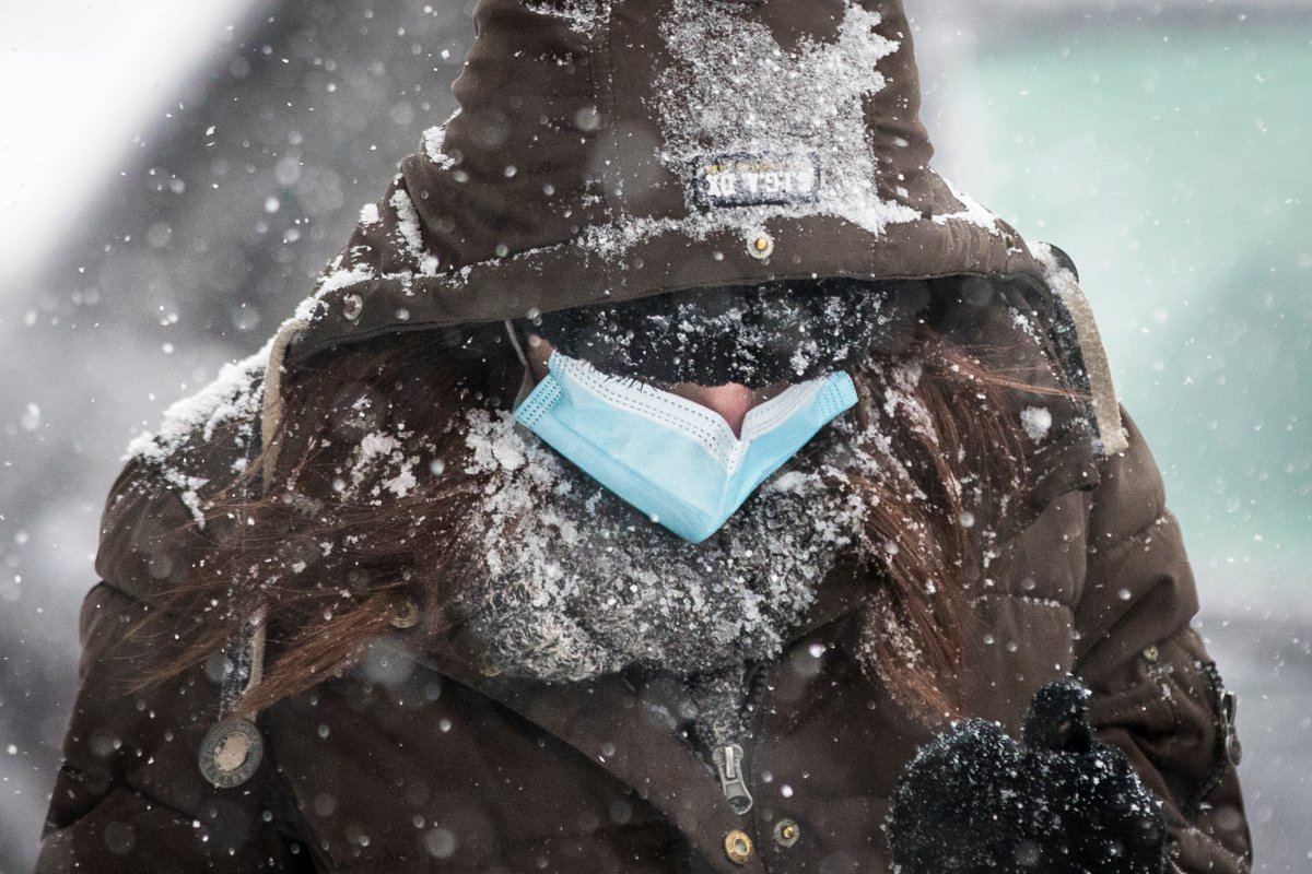 A person wears a disposable mask to protect them from the COVID-19 virus during a snow squall in Kingston, Ontario on Tuesday, January 26, 2021. 