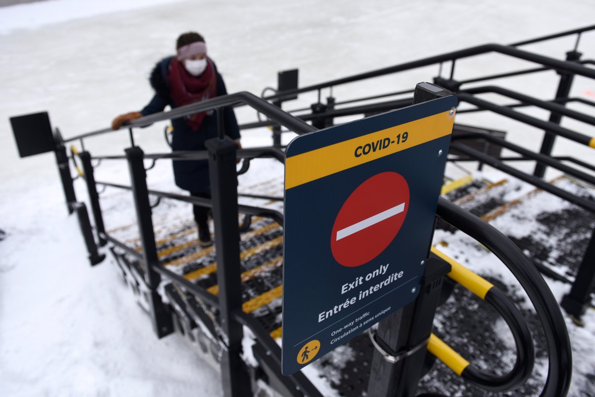 A person follows directions for one-way traffic on a staircase as they leave the Rideau Canal Skateway on its opening day in Ottawa, on Thursday, Jan. 28, 2021, in the midst of the COVID-19 pandemic.