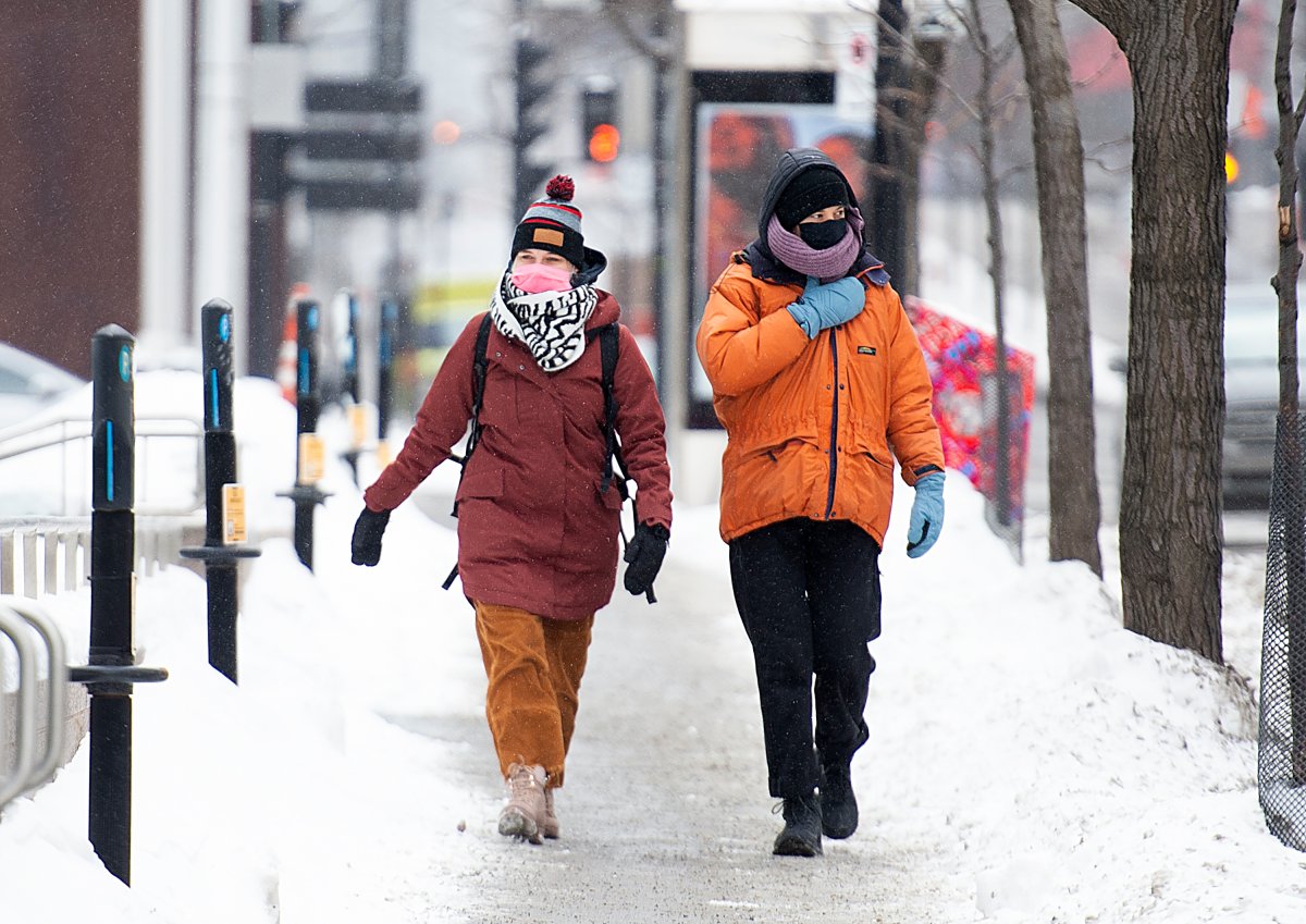 People wear face masks as they brave the cold weather in Montreal, Saturday, January 30, 2021, as the COVID-19 pandemic continues in Canada and around the world. 