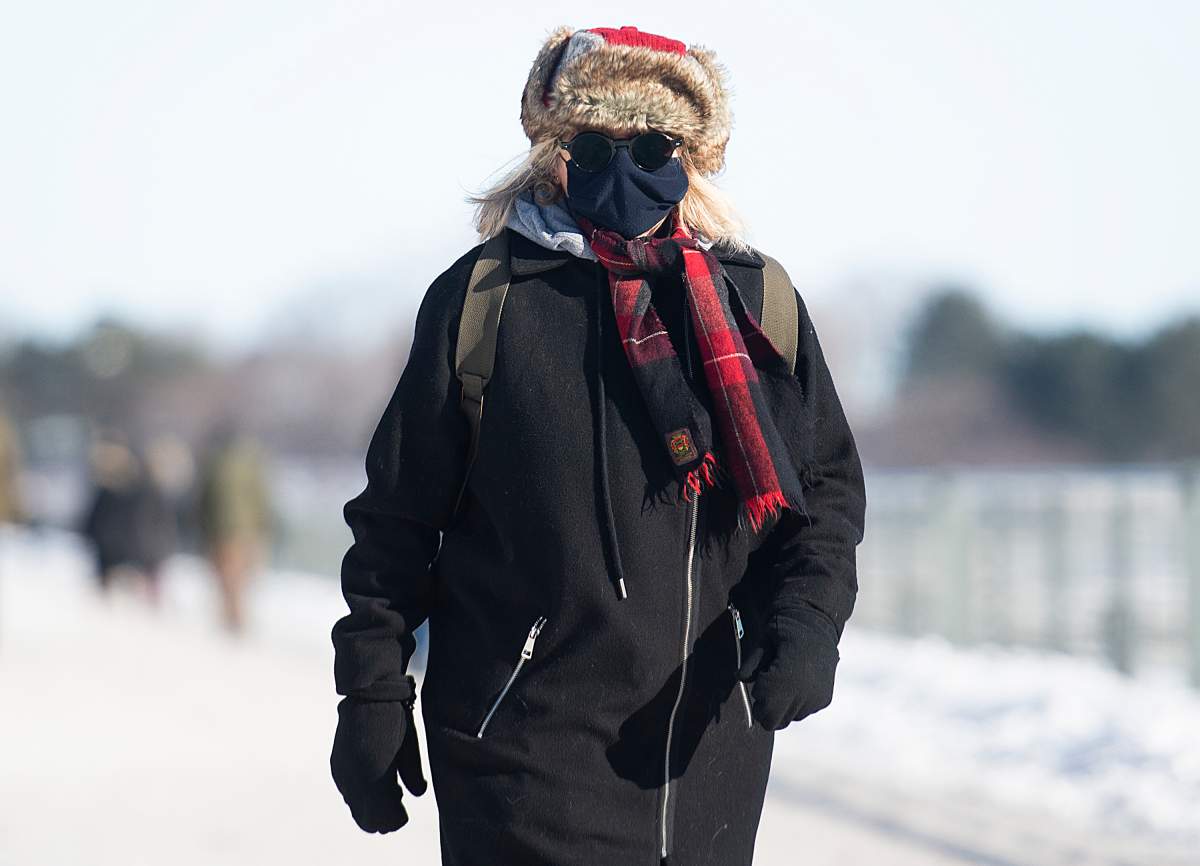 A woman wears a face mask as she braves the cold in Montreal, Sunday, Jan. 31, 2021, as the COVID-19 pandemic continues in Canada and around the world.