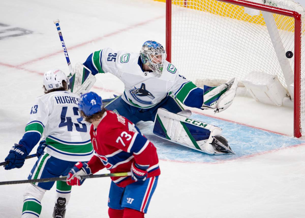 Montreal Canadiens right wing Tyler Toffoli (73) scores on Vancouver Canucks goaltender Thatcher Demko (35) as Canucks defenceman Quinn Hughes (43) looks on during second  period NHL hockey action Tuesday, February 2, 2021 in Montreal. 