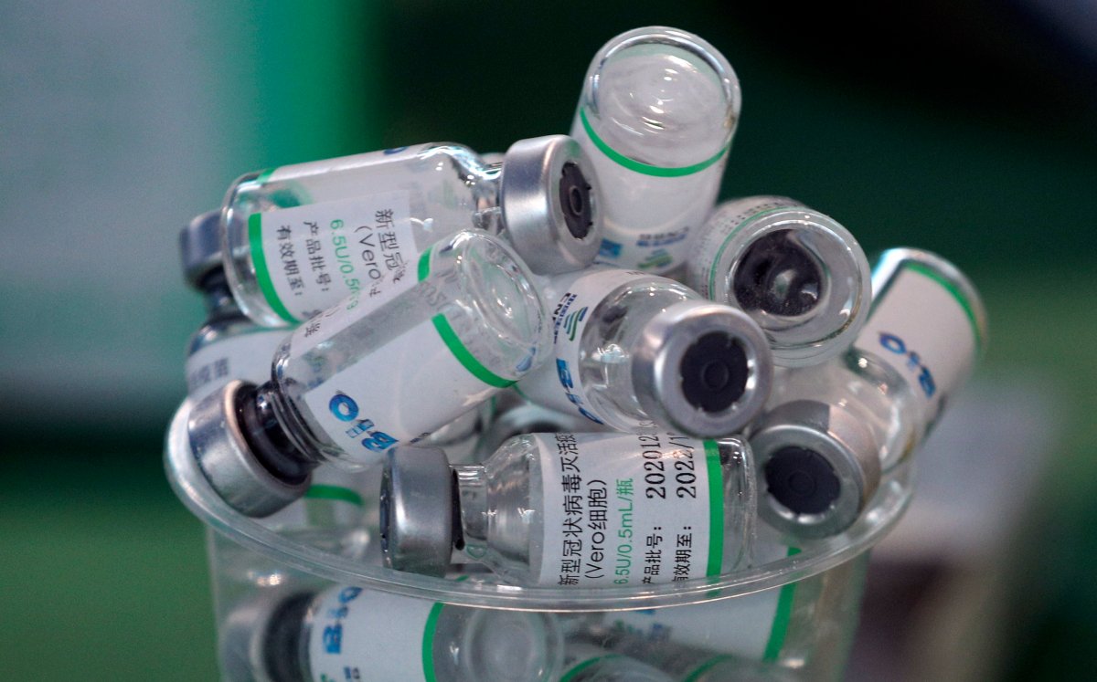 Empty vials of China's Sinopharm vaccine sit in a cup during a priority COVID-19 vaccination campaign of health workers at a public hospital in Lima, Peru, Wednesday, Feb. 10, 2021. Peru received its first shipment of COVID-19 vaccines on Sunday night. (AP Photo/Martin Mejia).