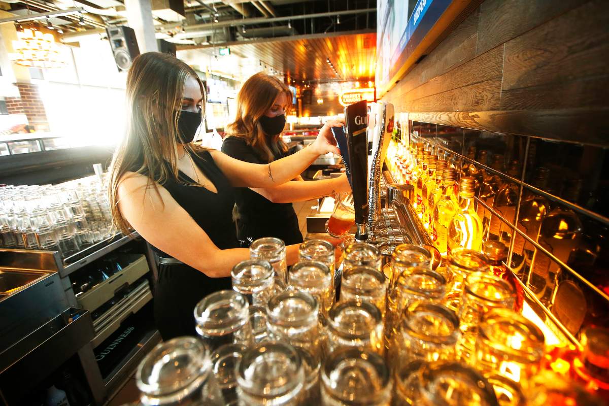 Browns Socialhouse bar manager, Jaz Hrem, left, and server Claire McCarvill set up the bar in preparation of re-opening as some COVID-19 restrictions are lifted in Winnipeg, Friday, February 12, 2021.