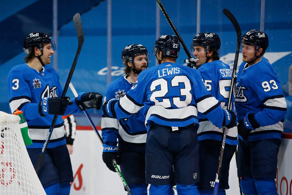 Winnipeg Jets’ Tucker Poolman (3), Josh Morrissey (44), Trevor Lewis (23), Mark Scheifele (55) and Kristian Vesalainen (93) celebrate Scheifele’s goal against the Ottawa Senators during second period NHL action in Winnipeg on Saturday, February 13, 2021.