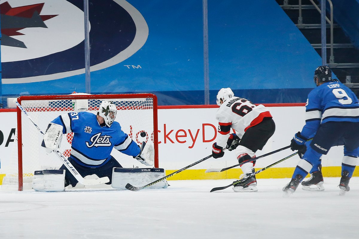 Ottawa Senators' Evgenii Dadonov (63) scores against Winnipeg Jets goaltender Connor Hellebuyck (37) during second period NHL action in Winnipeg on Saturday, February 13, 2021. 