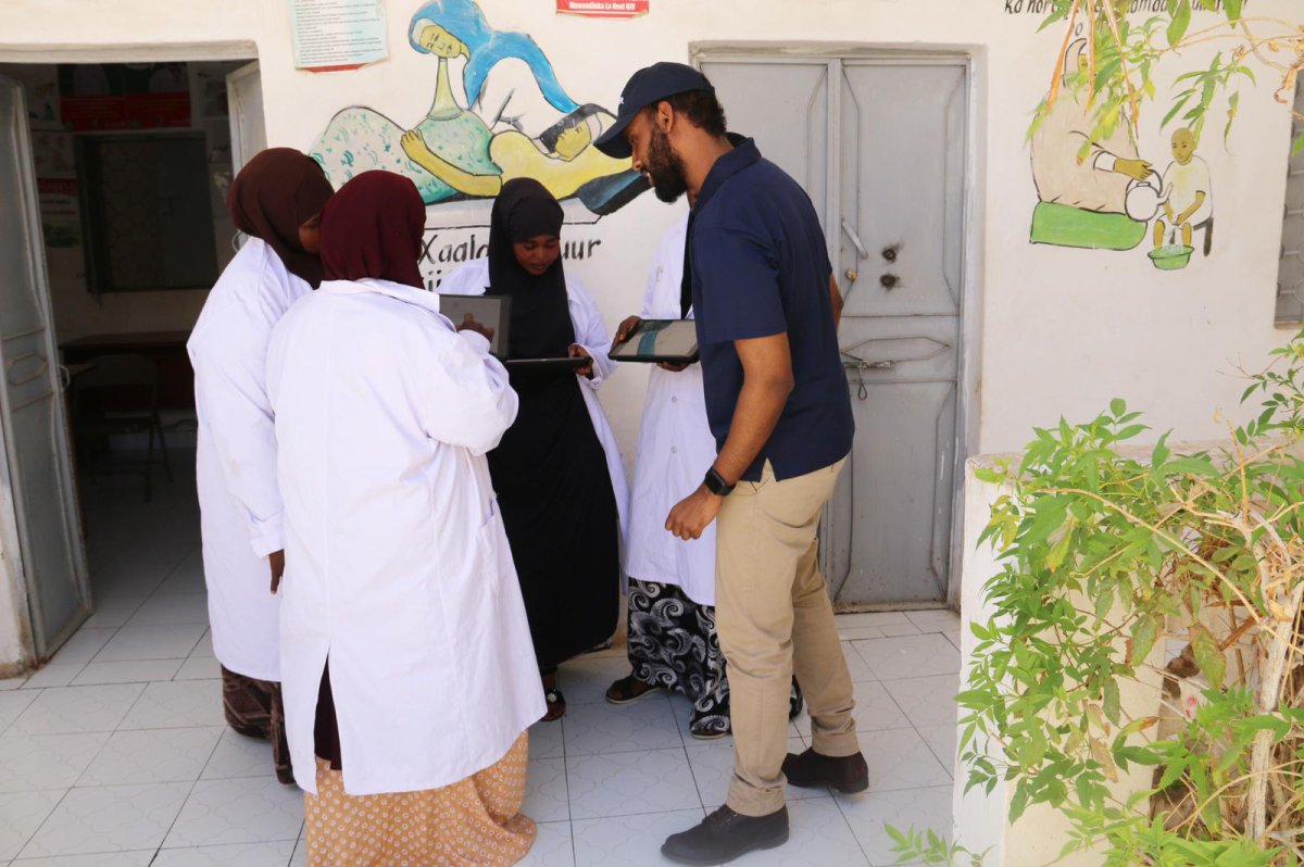 Canadian Khalid Hashi, right, shows informative videos about COVID-19 in his app OGOW EMR in Garowe, Puntland, Somalia, to frontline nurses and healthcare workers in an undated handout photo. Before Hashi created the app, which contains informative videos in Somali and Arabic about the novel coronavirus, Somalia only had public health messages about COVID-19 in English. 