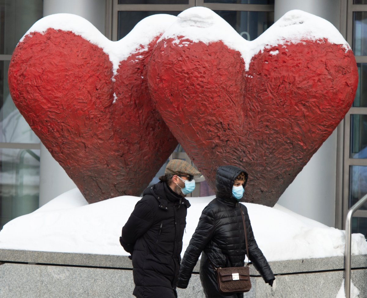 People walk past a sculpture in front of the Museum of Fine Arts Thursday, Feb. 18, 2021 in Montreal. 