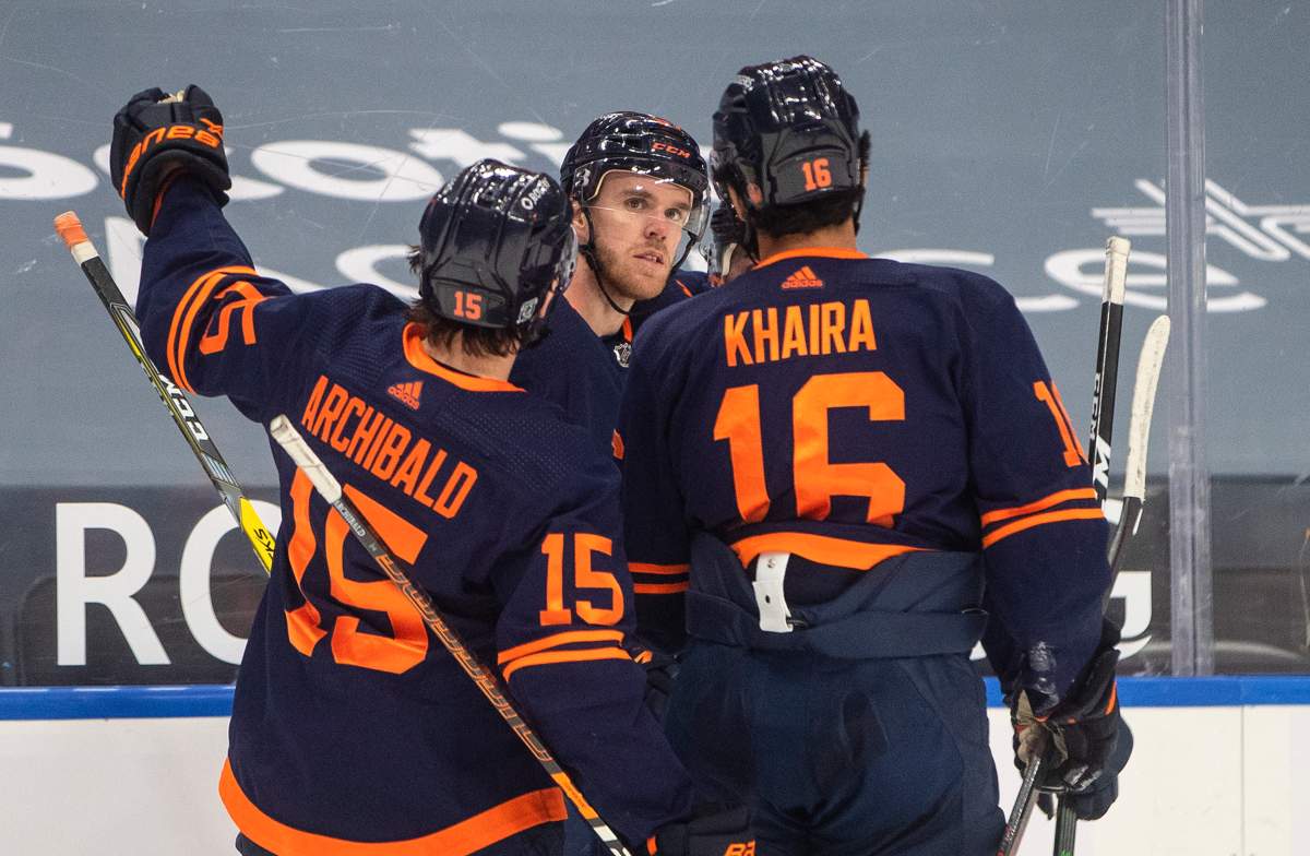 Edmonton Oilers' Josh Archibald (15), Connor McDavid (97), and Jujhar Khaira (16) celebrate a goal against the Calgary Flames during second period NHL action in Edmonton on Saturday, February 20, 2021. THE CANADIAN PRESS/Jason Franson.