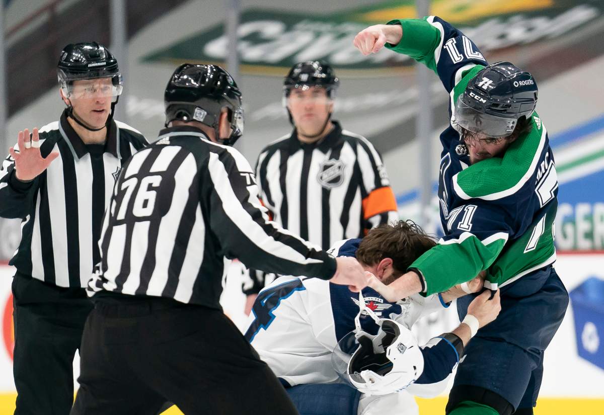 Vancouver Canucks centre Zack MacEwen (71) fights with Winnipeg Jets defenceman Derek Forbort (24) during first period NHL action in Vancouver, Sunday, Feb. 21, 2021.